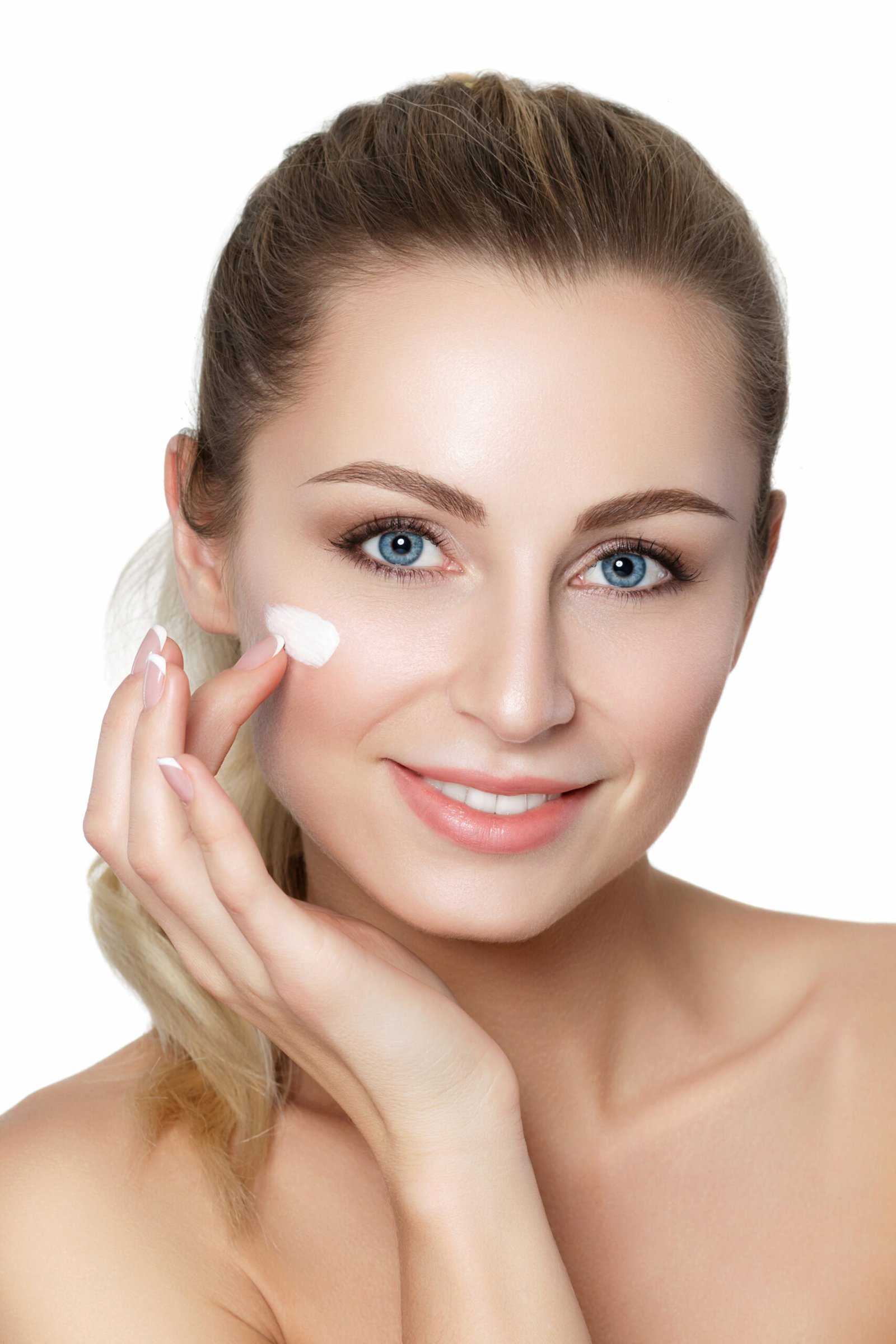 Beautiful young blonde woman applying moisturizing face cream